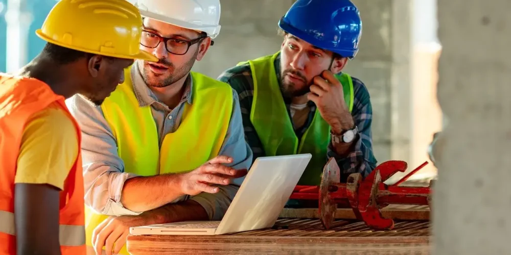 operario y técnicos en una obra